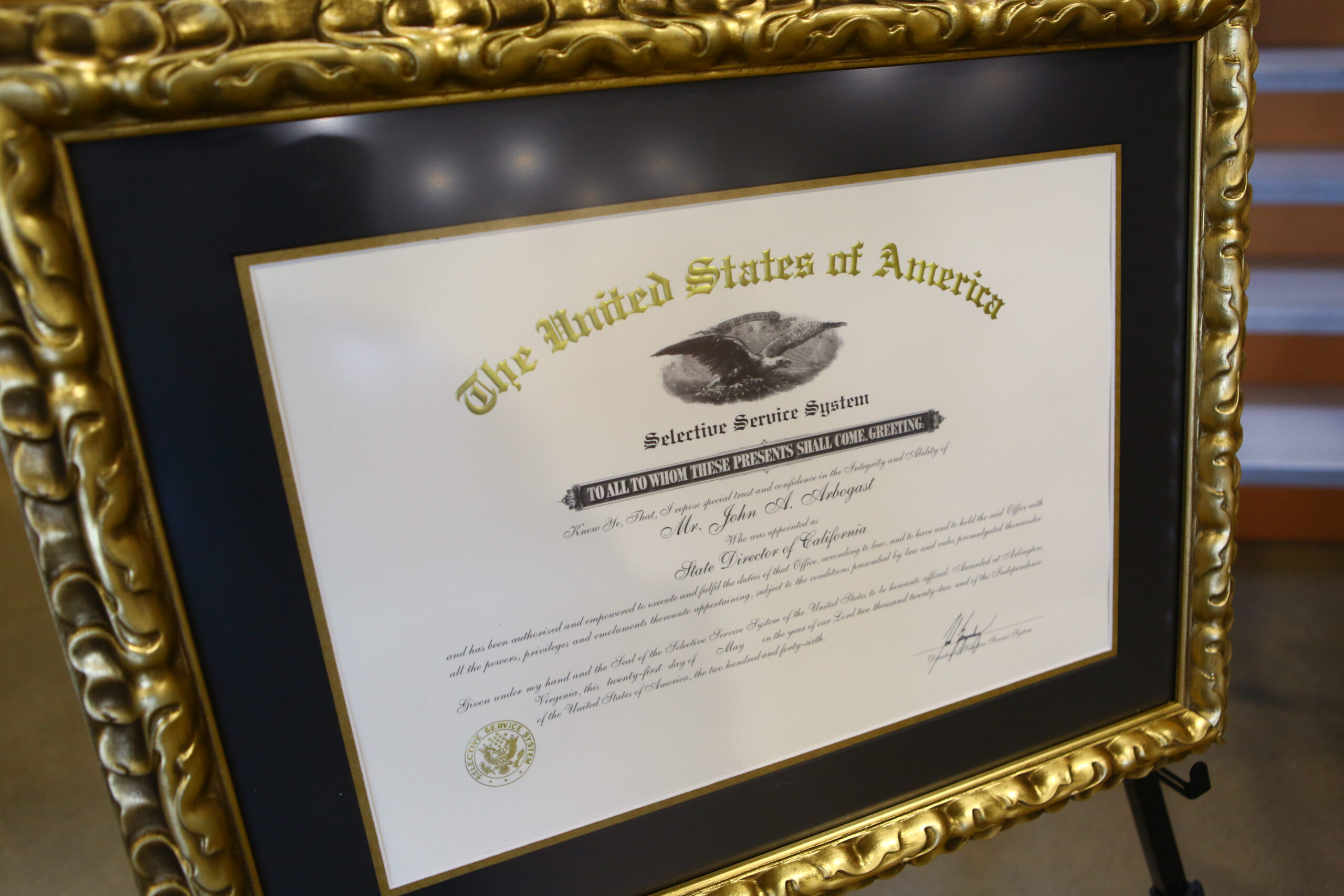 A framed appointment certificate is displayed for John A. Arbogast, the Selective Service System’s new state director for California,