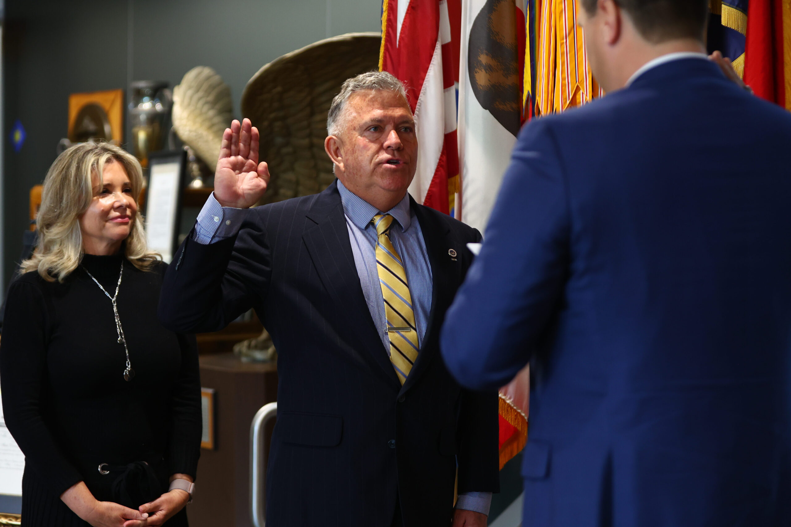 Selective Service System Acting Director Joel C. Spangenberg, right, administers the oath of office to John A. Arobgast, center, the system’s new state director for California, as Arbogast’s wife, Nancie, looks on during a ceremony